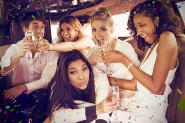 Composite image of happy friends drinking champagne - obrazy, fototapety, plakaty