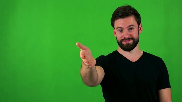 young handsome bearded man handshake - green screen - studio