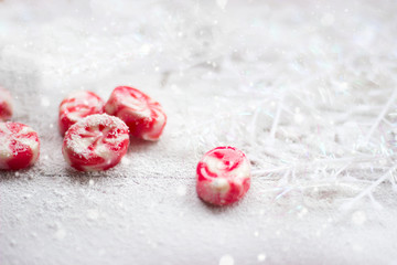 Obraz na płótnie Canvas Candies on white wooden background covered with snow