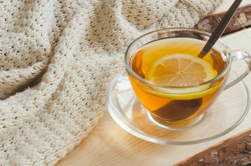 Cozy and soft winter background. Cup of tea and warm knitted sweater.