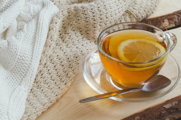Cozy and soft winter background. Cup of tea and warm knitted sweater.