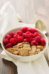 cereals with berries on white bowl on wooden background