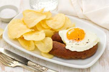 fried portuguese sausage alheira with egg and potato chips