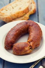fried portuguese sausage alheira on white plate and bread