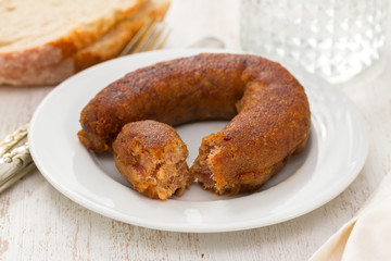 fried portuguese sausage alheira on white plate and bread