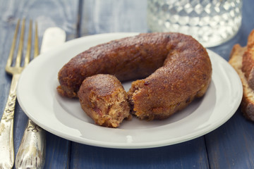 fried portuguese sausage alheira on white plate and bread