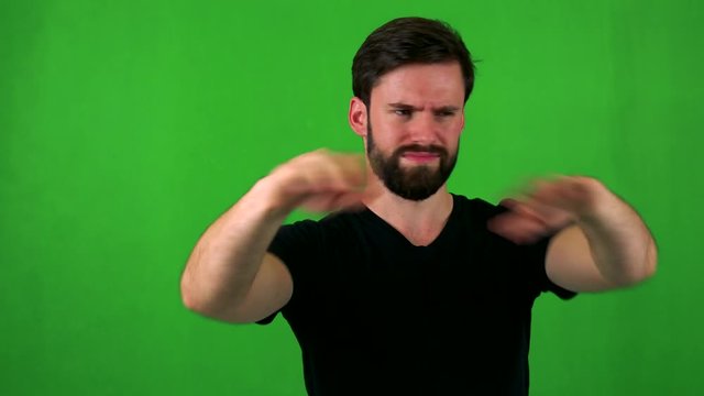young handsome bearded man is angry (protest) - green screen - studio