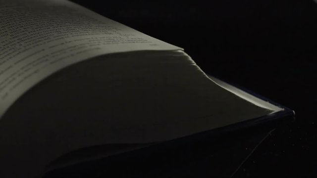 Flipping book pages over black background