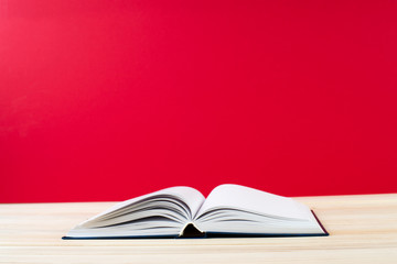 Open book, stack of hardback books on wooden table. Back to school. Copy space