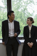 窓辺で話すビジネスパーソン