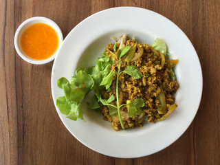 Top view of curry pork noodle in Thai style on wood table