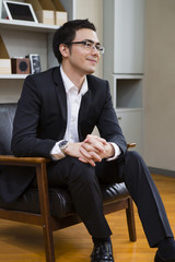 Fototapeta premium 座りながら話を聞くビジネスマン