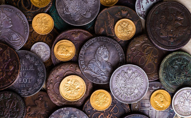 Gold and silver coins of the Russian Empire in the background ko