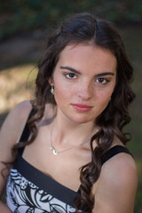 Naklejka premium Brunette model in black and white dress head and shoulders portrait.