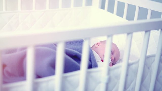sweet newborn infant baby girl sleeping in her crib