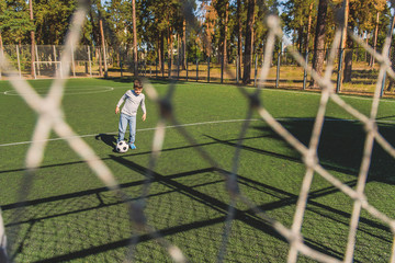Cute child playing football with joy