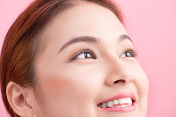Beautiful asian woman eye with long eyelashes isolated on pink b