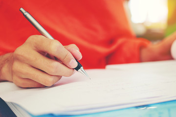 Monk's Hand writing in a book with the pencil