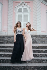 Portrait of two beautiful brunettes in long chiffon dresses stan