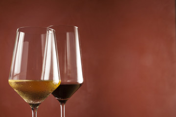 Red and white wine in glasses on left side of frame