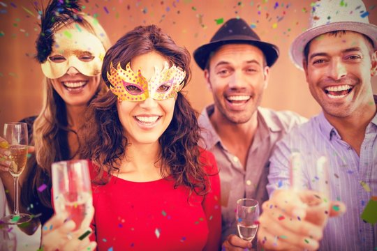 Composite image of portrait of friends holding champagne glasses