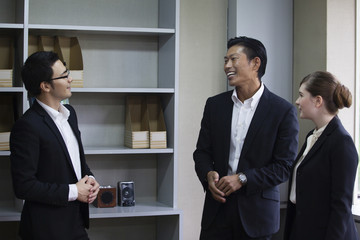 机を囲んで話すビジネスパーソン