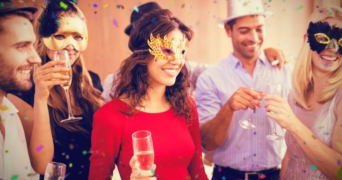 Composite image of friends with masks on holding champagne flute