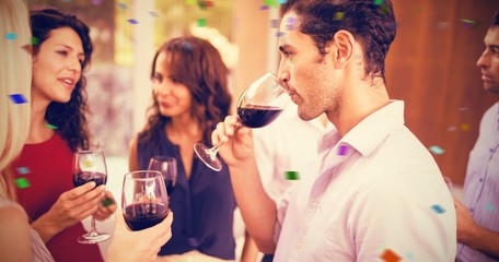 Composite image of group of friends having wine
