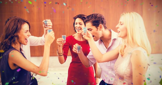 Composite image of friends toasting shots while standing togethe