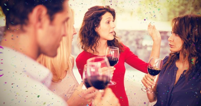 Composite image of friends having wine while standing together