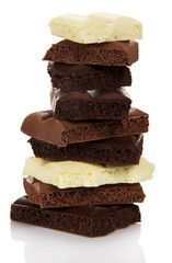 Tower of different pieces porous milk and black chocolate isolated.