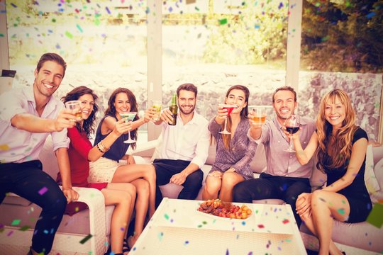 Composite image of portrait of friends having cocktail drinks