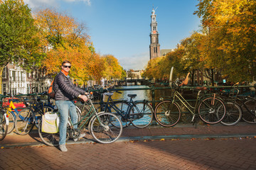 Fototapeta premium Tourist cycling along canals of Amsterdam