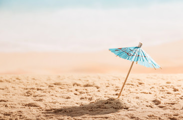 Fototapeta na wymiar Umbrella in the sand close up on coast.