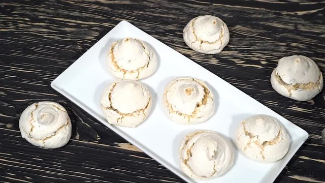 lot of white meringue cakes with tea.