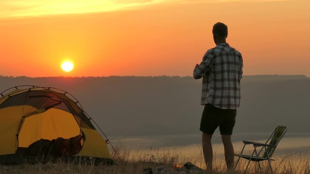 4K  Tent, bonfire, sunrise and man traveller  does  photo by smartphone	 

