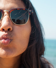 young woman sending a kiss in the beach