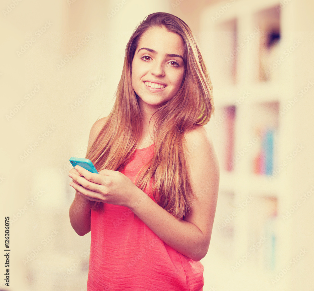 Wall mural young cute woman using her mobile on white background