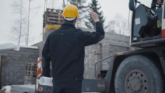Construction Worker Signals to Crane Operator on Construction Site.  on RED Cinema Camera in 4K (UHD)
