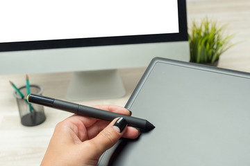Hand of graphic designer working with stilus and tablet