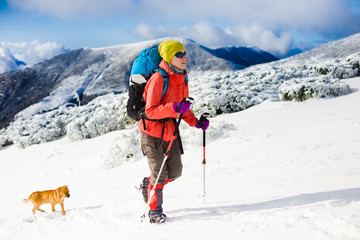 Girl with dog in winter mountains.