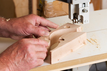 Carpenter tools on wooden table with sawdust. Band-saw to cut an intricate shape in a piece of wood.