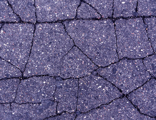 Damaged blue toned old asphalt road.