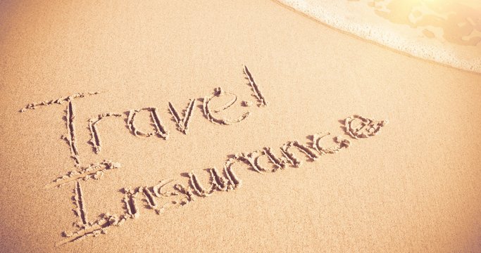 Travel Insurance written on sand