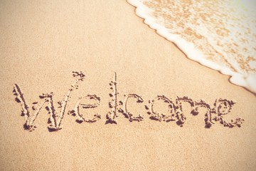 Fototapeta premium Welcome written on sand