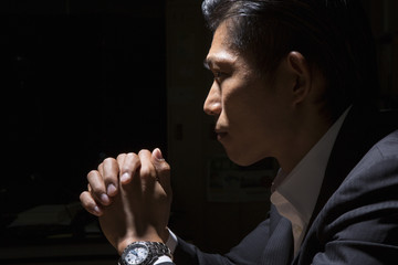 暗闇の中で手を組むビジネスマン