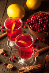 Two cups of red hot tea drink with fruits and spices on a wooden background. Mulled wine with cinnamon, anise and red berries. Winter hot drinks concept.
