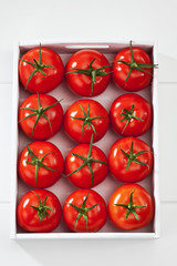 Strauchtomaten mit weissem Holztablett, weisser Holzuntergrund