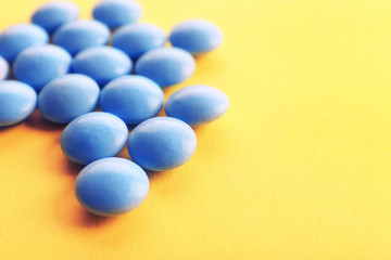 Heap of pills on yellow background