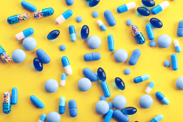 Heap of pills on yellow background